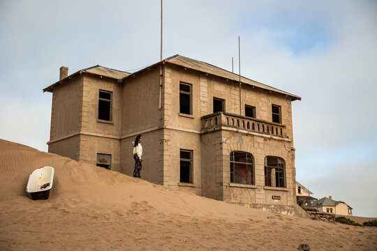 Woman exploring Kolmanskop ghost town ruins in Namibia