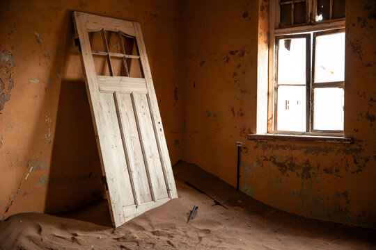 Abandoned door inside sand filled Kolmanskop building
