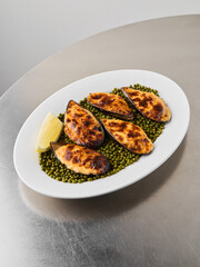 Charcoal toasted breadcrumb mussels presented on vibrant pea canvas © diczman