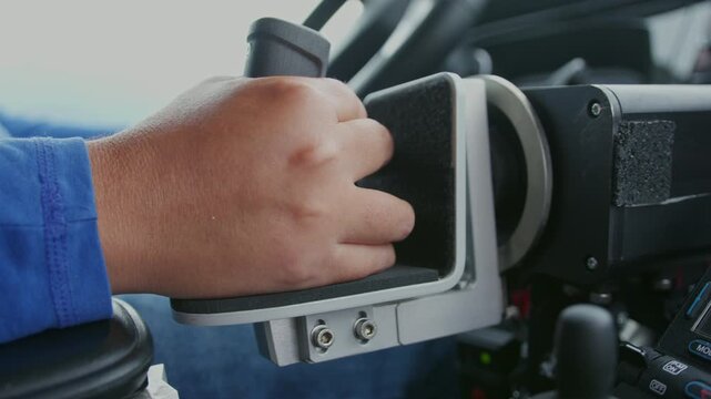 Close-up of adaptive hand controls used by a powered wheelchair user driving an adapted van. Independent mobility and accessible transportation.