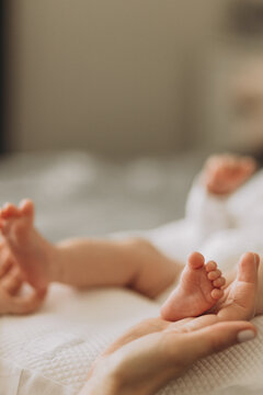 Newborn's Tiny Feet: Delicate baby feet, held gently in an adult's hand, symbolize new beginnings and the preciousness of new life. A close-up, intimate portrayal of innocence and love.