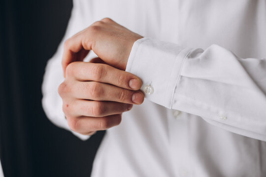 Man Adjusting Cufflink on White Shirt