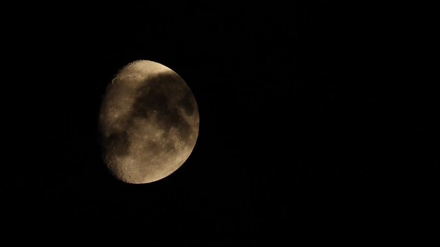 Detailed moon with passing dark clouds in the night sky