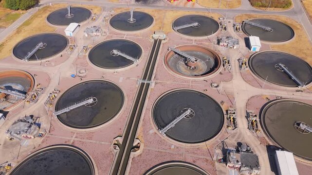 Aerial drone dolly style movement above clarifier tanks at a large scale waste water treatment plant in Minworth, UK