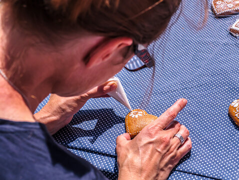 Woman Decorating Gingerbread Cookies With Icing