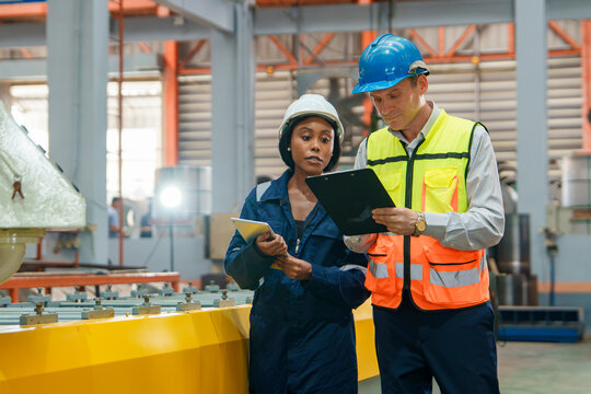 Workers Reviewing Safety Protocols and Notes in an Industrial Manufacturing Environment for Training Materials