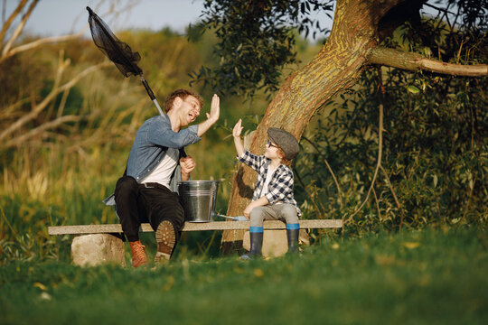 Young father teaching his little toddler son how to fish