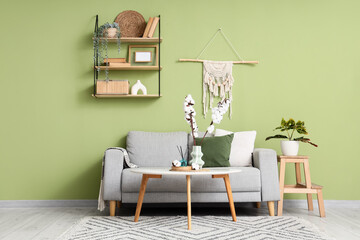Cozy living room interior design with modern furniture and green wall, home decor and comfortable...