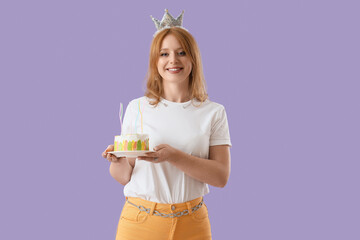 Naklejka premium Birthday celebration and party concept, happy young woman with crown holding a small cake with candles on purple background