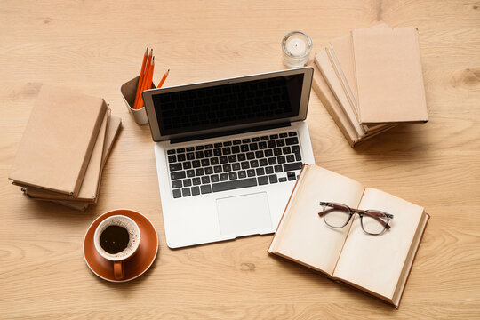 Remote work and home office setup overhead view of laptop books coffee and glasses on a wooden desk setup