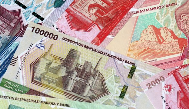 Uzbekistani som money bills in pile on table. Uzbekistan UZS currency cash close up