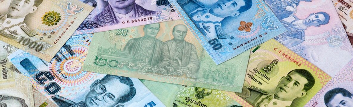 Thai baht money bills in pile on table. Thailand THB currency cash close up