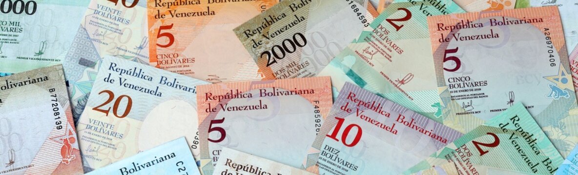 Venezuelan bolivar money bills in pile on table. Venezuela VES currency cash close up