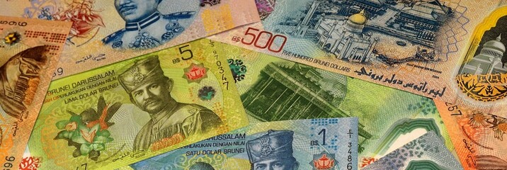 Brunei Darussalam dollar money bills in pile on table. Brunei BND currency cash close up © Viktor