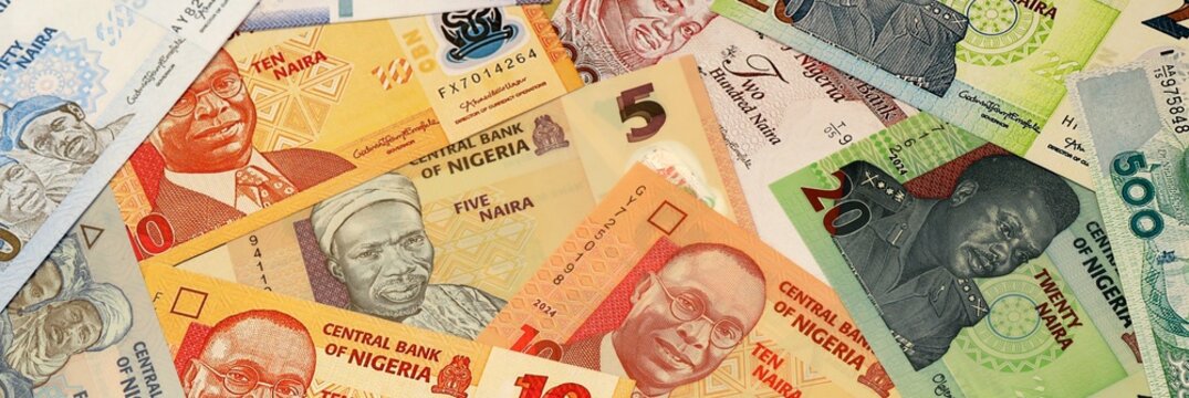 Nigerian naira money bills in pile on table. Nigeria NGN currency cash close up