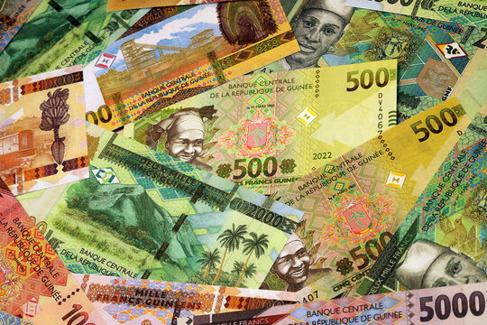 Guinean franc money bills in pile on table. Guinea GNF currency cash close up