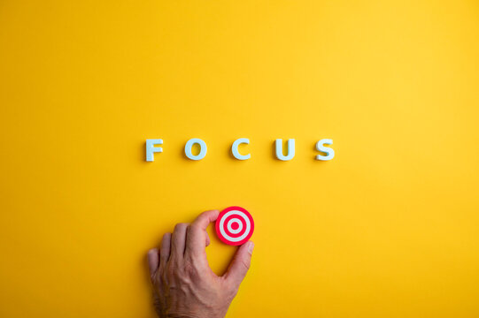 Focus, concentration and goal achievement concept with hand holding target