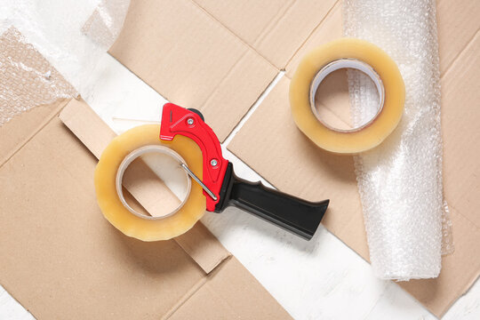 Moving and packing supplies, cardboard boxes with tape dispenser and bubble wrap for shipping and relocation