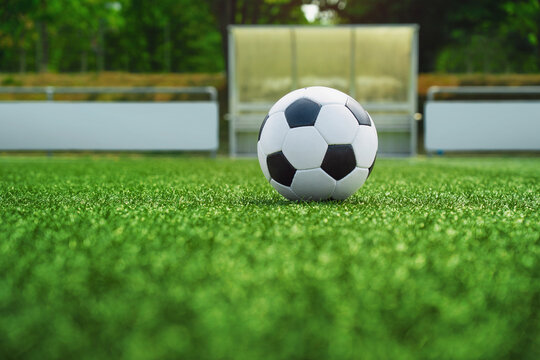 textured soccer game field with ball in front of the soccer goal. - center, midfield