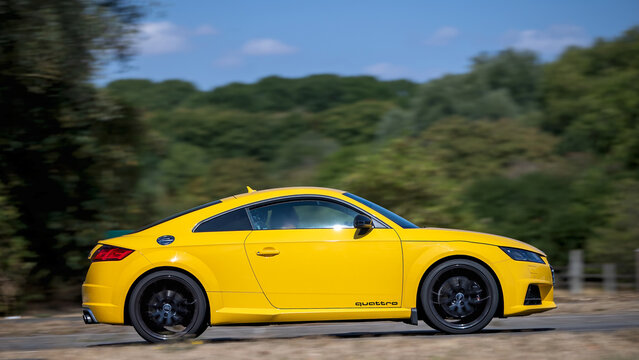 Milton Keynes; UK - Aug 23rd 2026:; 2016 yellow Audi tt tts tfsi Quattro coupe car driving on a British road