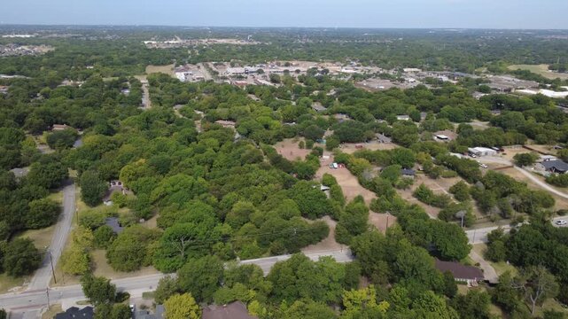 Expansive wooded parcels transition into suburban communities near Hampton Road. Large acreage homesteads, winding local roads border dense deciduous green forest groves, DeSoto, Texas