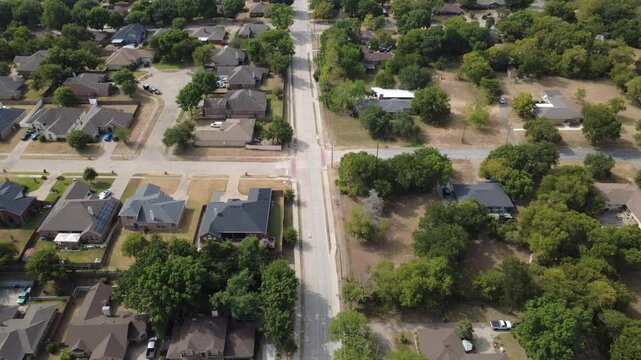 Curving residential cul de sacs branch off collector roads near Ernie Roberts Park. Single family brick residences feature solar rooftop panel arrays, paved driveway loops, DeSoto, Texas