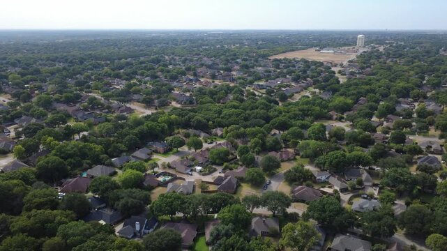 Curved residential courts feature backyard swimming pools near Ramblewood enclave. Multiple distinct hip rooflines integrate seamlessly into mature green suburban foliage, DeSoto, TX