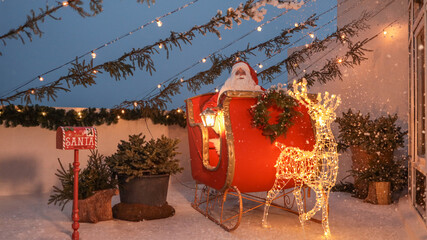 Santa Claus in his sleigh with reindeer and festive decorations on a snowy night © shine.graphics