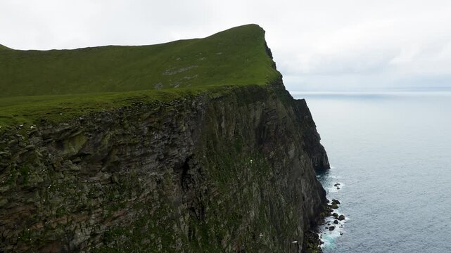 Thousands of seabirds flying around the towering cliffs of the Isle of Foula, Shetland, Scotland, United Kingdom