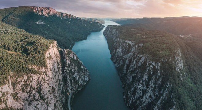 Danube River flowing through the imposing Iron Gates gorge, with steep rock cliffs and green forests on both sides