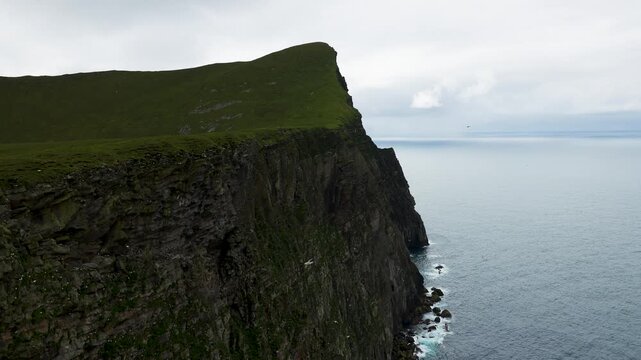 Thousands of seabirds flying around the towering cliffs of the Isle of Foula, Shetland, Scotland, United Kingdom