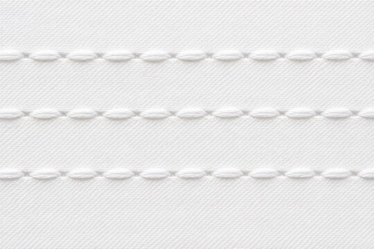 White fabric with parallel stitched seams textile surface closeup