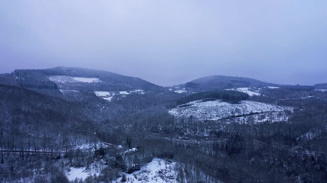 Aerial view of the snow-covered hills and forests of the Morvan region, focusing on the Haut Folin area in Burgundy, France.