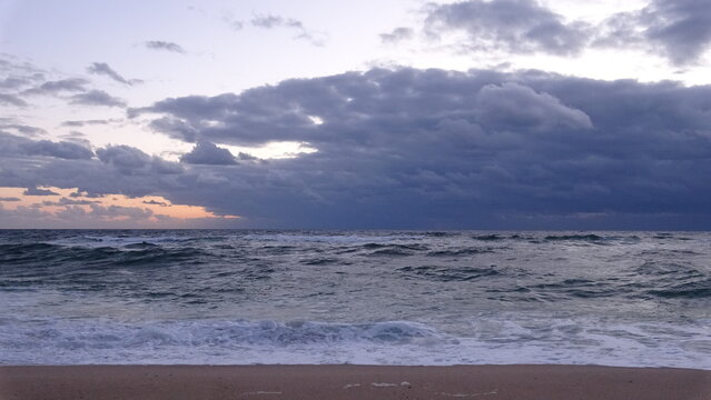 Dramatic Dawn Sky over Ocean on Sandy Beach.
A dramatic dawn scene at Gangneung beach in South Korea featuring heavy dark clouds over rolling ocean waves and golden light breaking on the horizon.