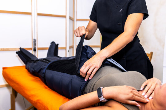Woman undergoing pressotherapy treatment, receiving lymphatic drainage therapy