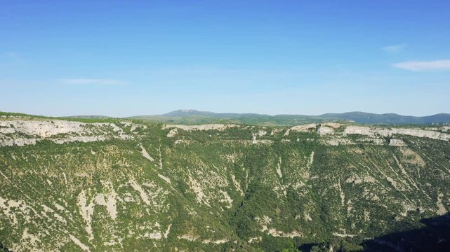 Wide aerial footage of the Cirque de Navacelles, a dramatic limestone canyon in the Occitanie region of southern France.