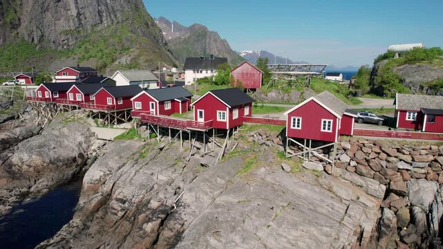 Picturesque red wooden fishing cabins, known as rorbuer, dotting the rocky coastline of the Lofoten Islands in northern Norway