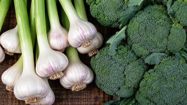 Fresh Garlic Bulbs and Green Broccoli Arranged on Rustic Wooden Background