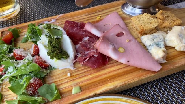Italian Appetizers with Burrata, Salad, Cured Meats and Ham on Restaurant Table