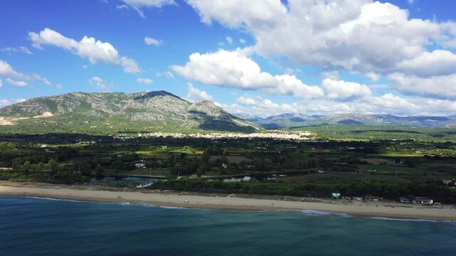 Aerial panoramic footage of Orosei, a town in Sardinia, Italy, seen from the beach. No people are visible on the beach, emphasizing a peaceful coastal atmosphere.