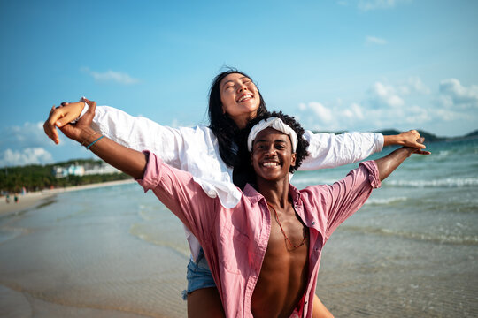 Beautiful diverse couple enjoying in good mood on the beach. Lifestyle love dating vacation concept