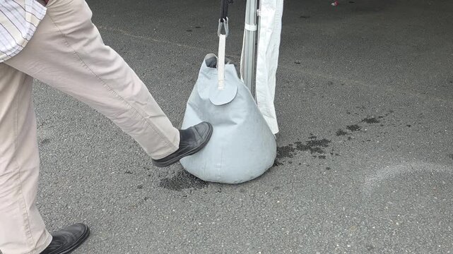 A waterbag is placed on the ground to hold a tent