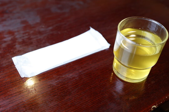 そば茶。ガラスのコップに入った黄色い健康飲料。白いコースター。