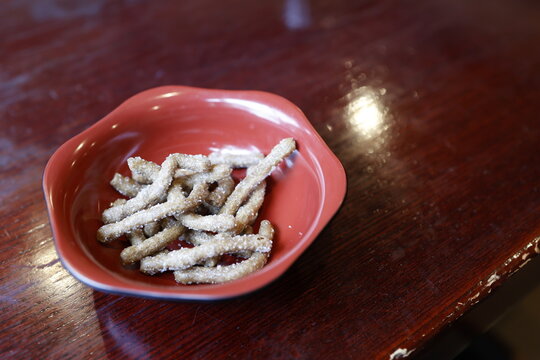 そば粉かりんとう。赤い器に盛った日本の揚げ菓子。砂糖がけ。