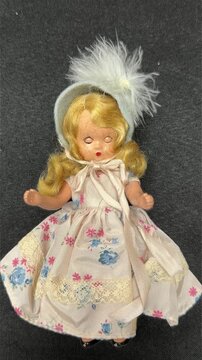 Looping blinking blonde hair bisque vintage doll isolated on black fabric