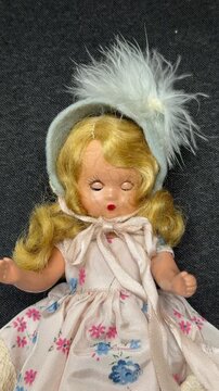 Looping blinking blonde hair bisque vintage doll isolated on black fabric