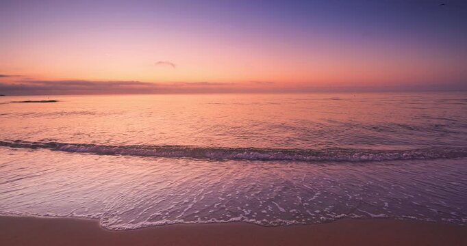 Golden sunrise with scenic cloudscape over sea horizon and beach shore