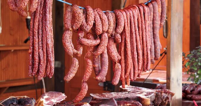 Traditional smoked sausages hanging on rope at street market