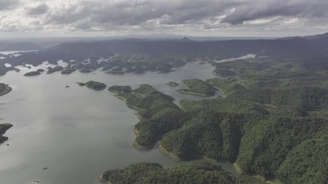 Aerial drone view of Ta Dung Lake surrounded by hundreds of green island hills and mountains in Ta Dung Commune, Lam Dong Province, Vietnam. View from QL 28. D Log mode