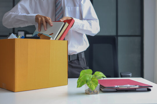 Business professional packing up belongings after getting laid off.
